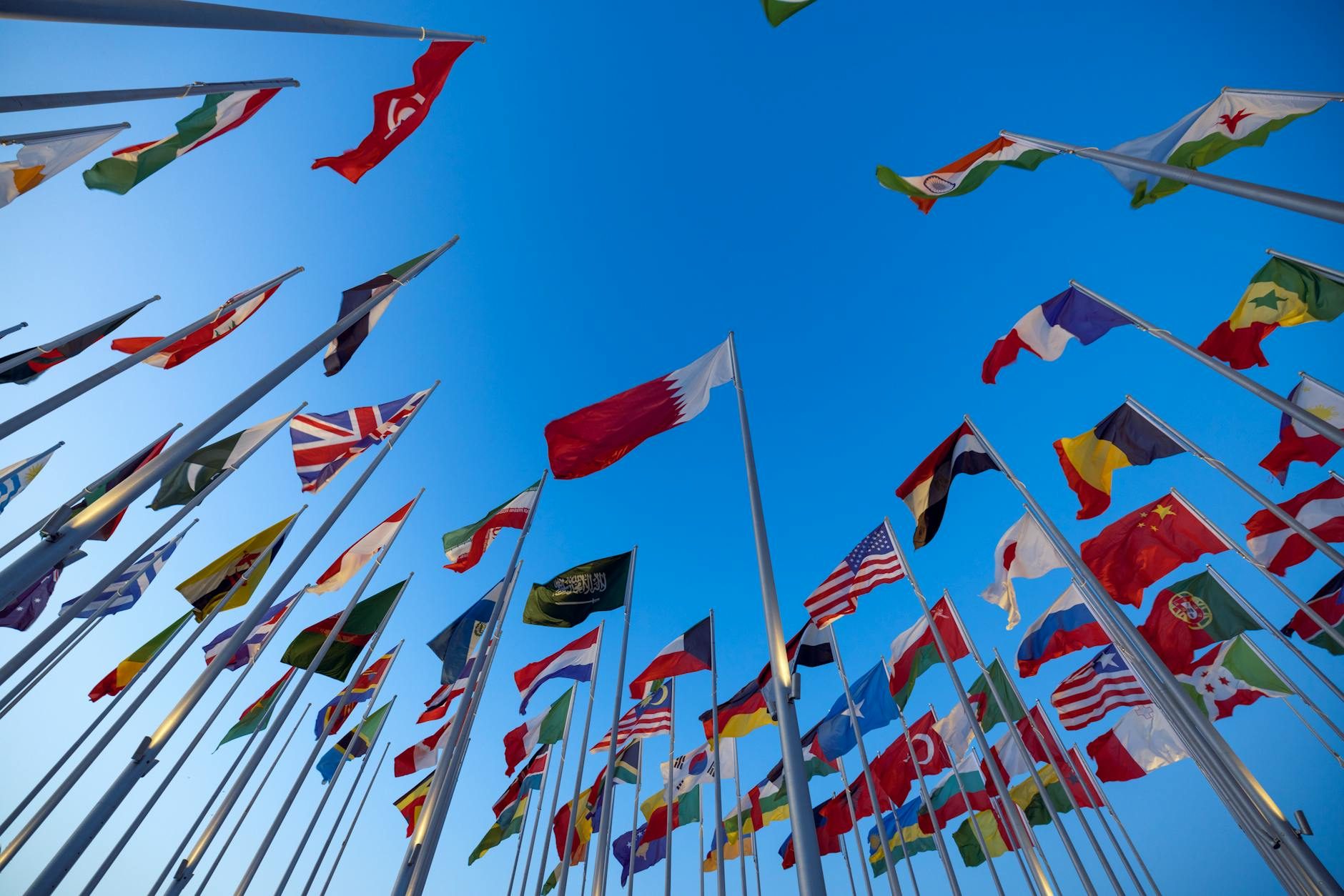 low angle shot of flags on the background of a clear blue sky